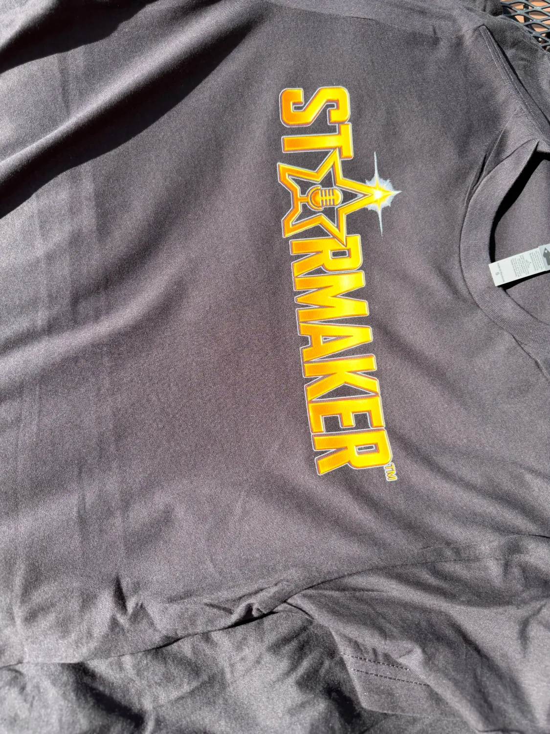 Gold gradient “Starmaker” logo printed on a black tee