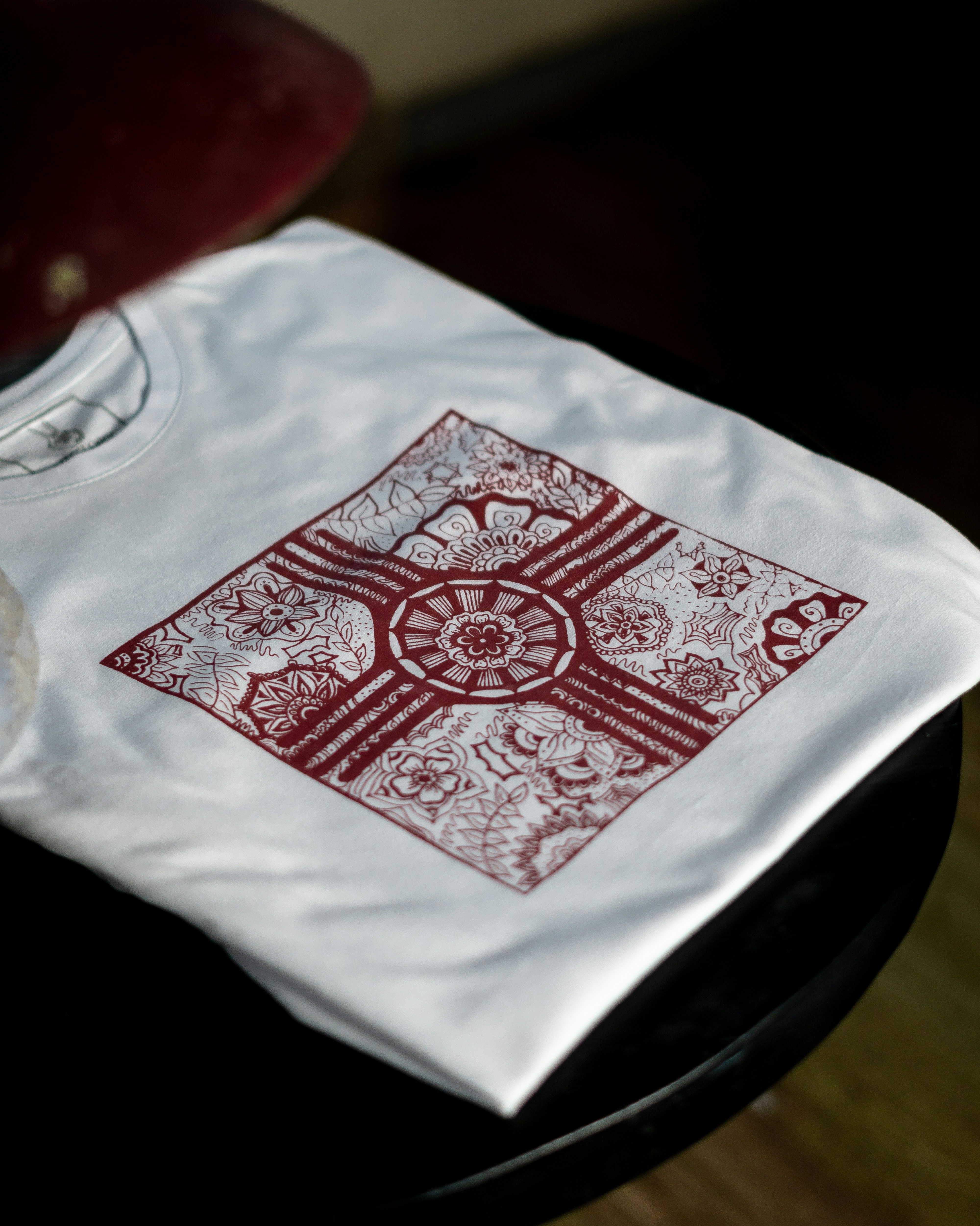 Crisp floral design pritned in maroon on a white shirt in a crucian form.